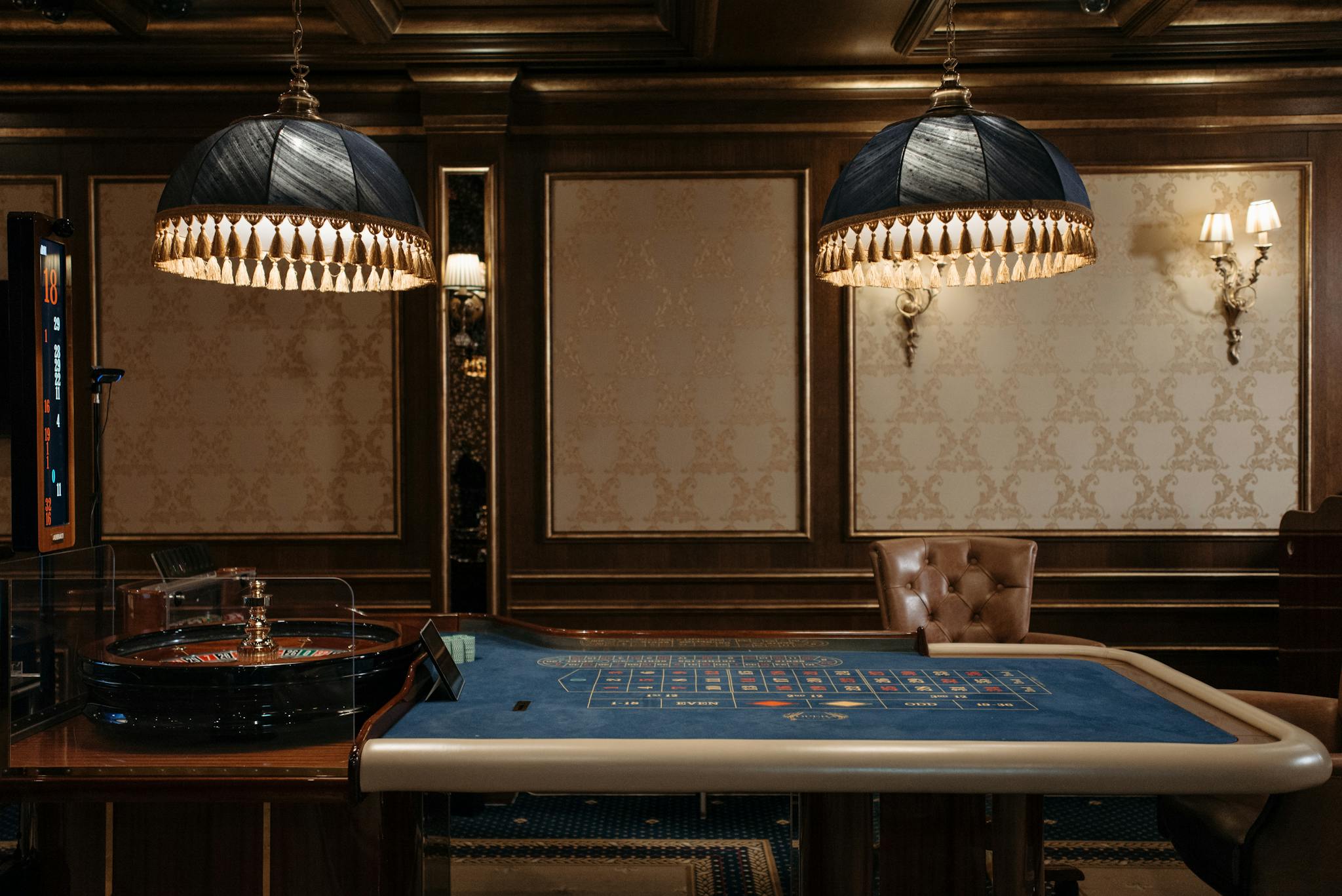Home Luxurious casino interior featuring a traditional roulette table under stylish lamps.